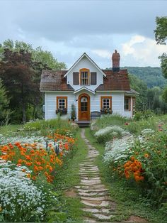 a white house surrounded by flowers and trees