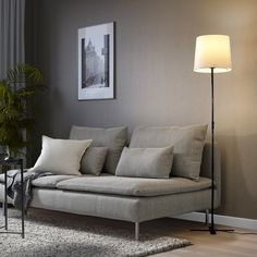 a living room scene with focus on the couch and floor lamp in the foreground