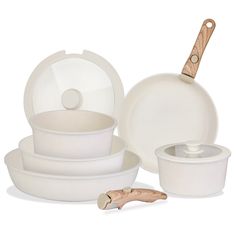 white dishes with wooden handles are stacked on top of each other and one is empty