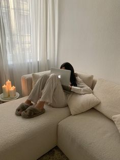 a woman sitting on a couch using a laptop computer