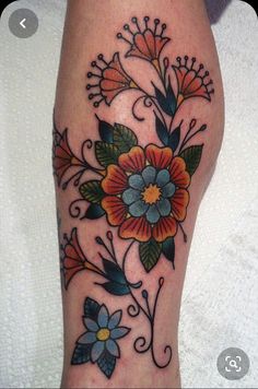 a colorful flower tattoo on the leg