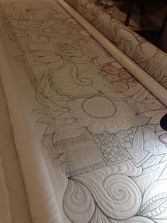 a close up of a bed with an intricate design on it