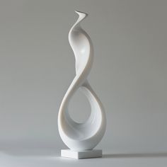 a white sculpture sitting on top of a table next to a gray wall and floor