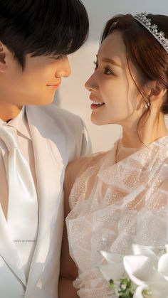 a man and woman are dressed in wedding attire, one is wearing a tiara