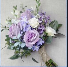 a bridal bouquet with purple and white flowers on a linen background for a wedding or special occasion