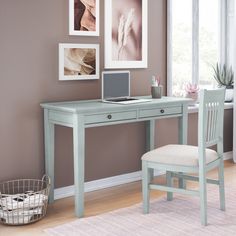 a desk with a laptop computer on top of it next to a chair and potted plant