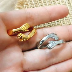 two gold and silver rings in the palm of someone's hand