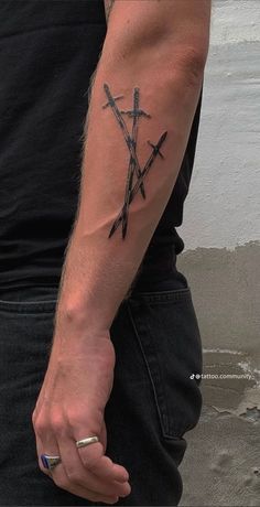 a man with a tattoo on his arm holding two swords in one hand and an arrow in the other