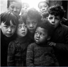 black and white photograph of children posing for the camera with their heads turned to look like they are making faces