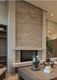 a living room filled with furniture and a fire place in front of a stone wall