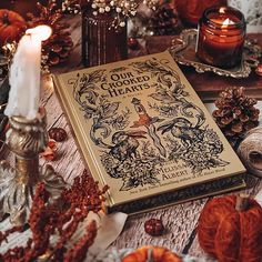 a book sitting on top of a wooden table next to candles and other items in front of it