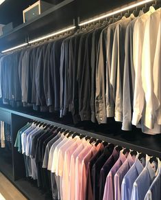 an assortment of men's shirts are on display in a clothing store with black shelves