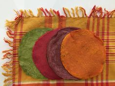 four different colored tortillas sitting on top of a table