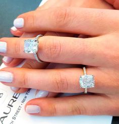 a woman's hand with two engagement rings on it