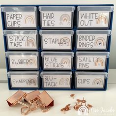 several stacks of paper clips next to each other on top of a white table with blue bins