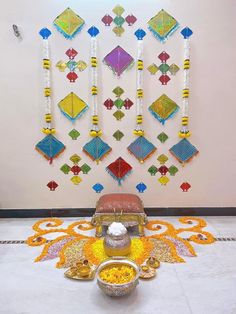 an arrangement of decorative items on display in front of a white wall with colorful designs