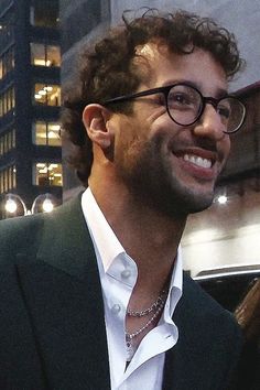 a man wearing glasses is smiling for the camera