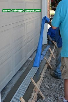 a man in blue shirt working on a garage door