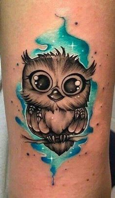 an owl tattoo on the leg with blue watercolor splashes and stars around it