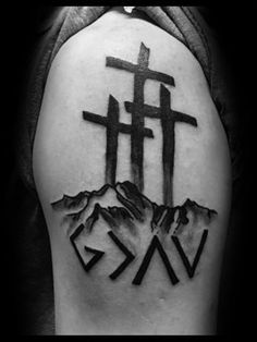 a black and white photo of a person with a cross tattoo on his arm