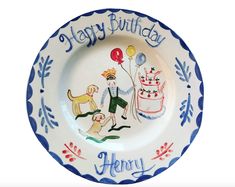 a happy birthday plate with an image of two people and a dog holding balloons on it