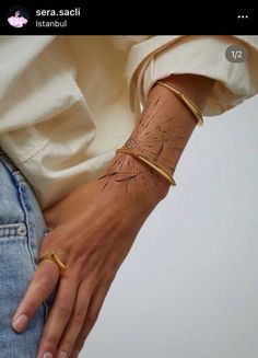 a woman's arm with a bracelet on it and a dandelion tattoo