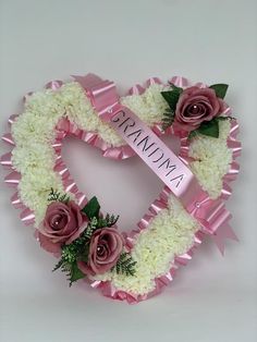 a pink and white heart shaped wreath with flowers on the side that says namma