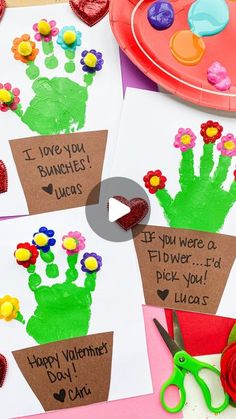 three handprints with flowers on them are displayed next to some scissors and paper