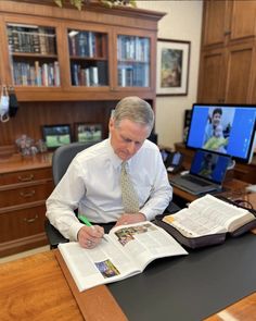 a man sitting at a desk with an open book