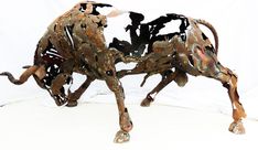 a metal sculpture of a cow is shown on a white background with the legs bent down