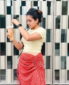 a woman in a red skirt holding a cup