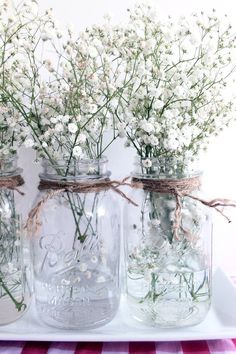 three mason jars filled with baby's breath flowers