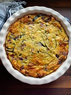 a casserole in a white dish on top of a wooden table