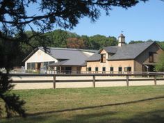 a large house with a fence around it and trees in the backgrouds