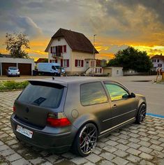 a car parked in front of a house at sunset