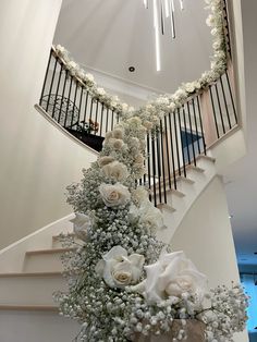 a bunch of flowers that are sitting on the ground in front of a stair case