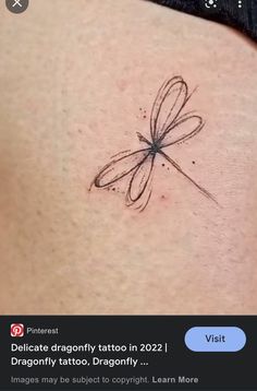 the back of a woman's stomach with a dragonfly tattoo on it