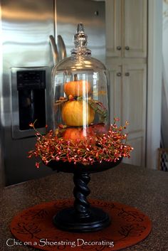 a glass clochel filled with fruit on top of a counter