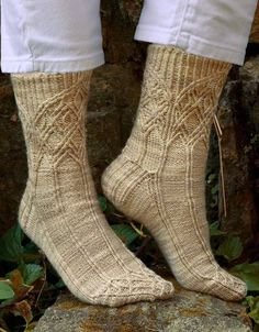 a person standing on top of a rock with their feet up in knitted socks