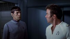 two men standing next to each other in front of a mirror, one wearing a star trek uniform