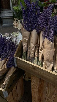 lavender flowers in brown paper bags sitting on wooden crates