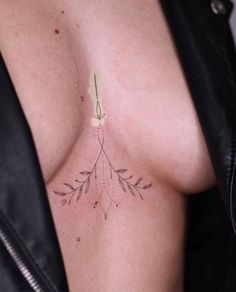 a woman's chest with an arrow tattoo on it