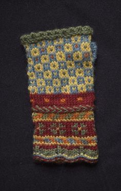 a knitted piece of cloth with multicolored stripes on black background, close up