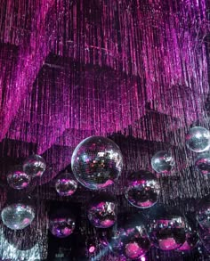 disco balls hanging from the ceiling in front of purple lights