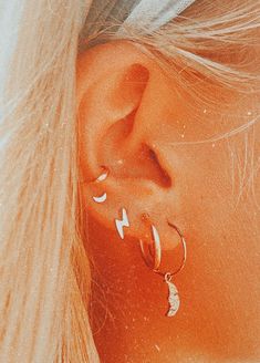 a close up of a person with ear piercings on their ears and wearing earrings