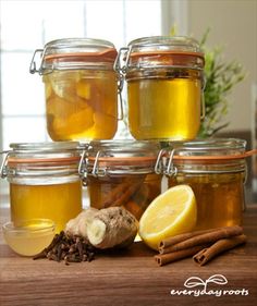 several jars filled with different types of liquid and spices on top of a wooden table