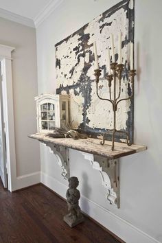 an old mantle with candles on it in front of a large piece of art hanging on the wall