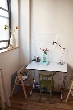 a white desk with a green chair next to it and a window in the background