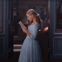 a woman in a blue dress reading a book