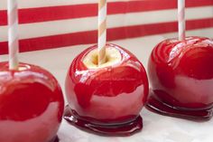 three candy apples with candles sticking out of them